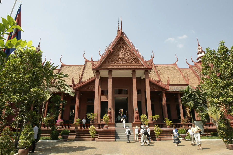 In this Wednesday, Feb. 27, 2013, foreign tourists enter a museum, in Phnom Penh, Cambodia. Phnom Penh's developing tourism sector also means that nearly every attraction has an entry fee, even if just a dollar or two. But in keeping with history, some sites cost nothing at all. (AP Photo/Heng Sinith)