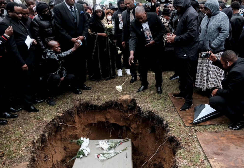 Peter Lyoya throws a flower into the grave of his son Patrick Lyoya, an unarmed Black man who was fatally shot and killed by a Grand Rapids Police officer during a traffic stop on April 4, during the funeral in Grand Rapids, Mich., on April 22.<span class="copyright">Michael A. McCoy—Reuters</span>