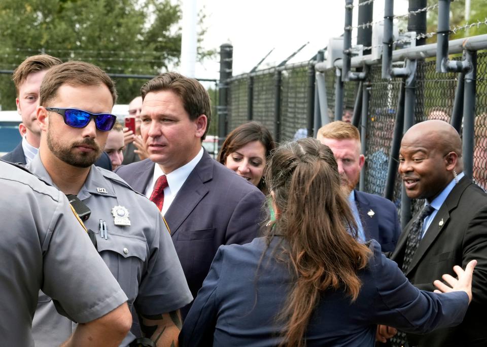 Gov. Ron DeSantis visits with Embry-Riddle Aeronautical University students crowded along a fence line after holding a news conference on the Daytona Beach campus on Friday.