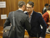 Oscar Pistorius, talks with his brother Carl, right, inside court on the second day of his trial at the high court in Pretoria, South Africa, Tuesday, March 4, 2014. Pistorius is charged with murder for the shooting death of his girlfriend, Reeva Steenkamp, on Valentines Day in 2013. (AP Photo/Kim Ludbrook,Pool)