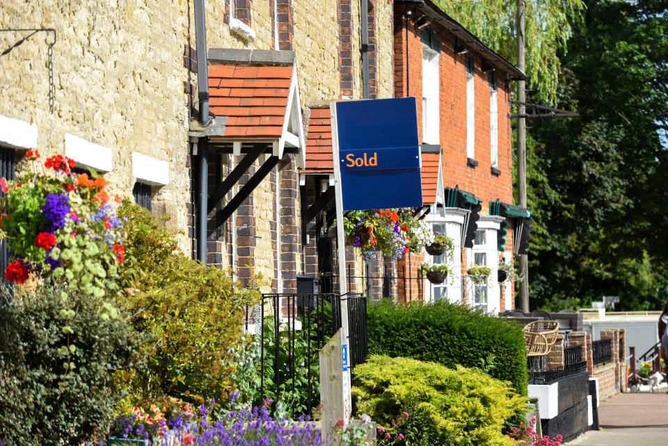 House for sale sign reading sold by estate agent or real estate letting house prices