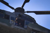 Brazil's President Jair Bolsonaro waves to supporters from a military helicopter overflying the presidential palace in Brasilia, Brazil, Sunday, May 31, 2020. Bolsonaro mounted a horse from police that were guarding supporters of his government gathered outside the Planalto Palace. (AP Photo/Andre Borges)