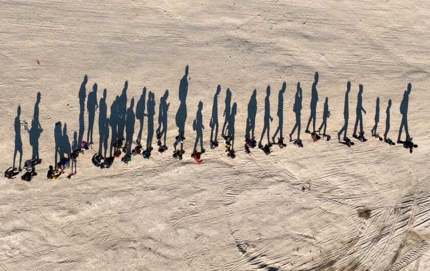 Eagle Pass, Texas, Saturday, September 23, 2023 - People who crossed the US/Mexico border are led, single file, to a border patrol processing center along the banks of the Rio Grande. (Robert Gauthier/Los Angeles Times)