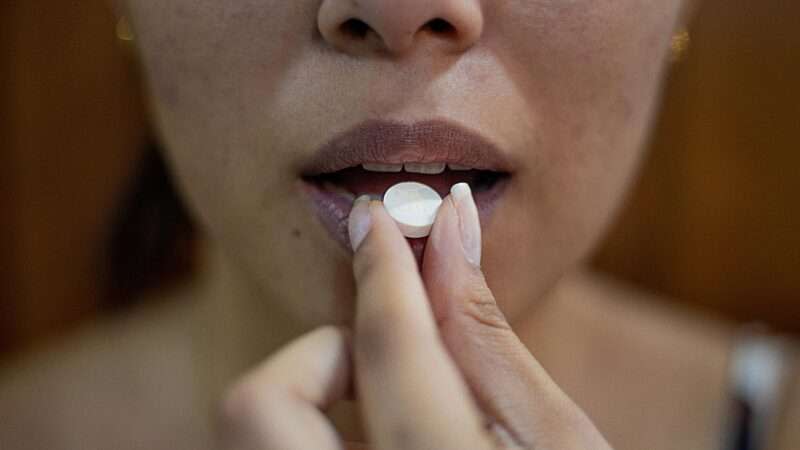 A woman taking a pill