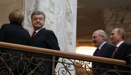 German Chancellor Angela Merkel walks with Ukraininan President Petro Poroshenko as he looks back, followed by Belarussian President Alexander Lukashenko and Russian President Vladimir Putin (L-R) after a meeting in Minsk, February 11, 2015. REUTERS/Grigory Dukor