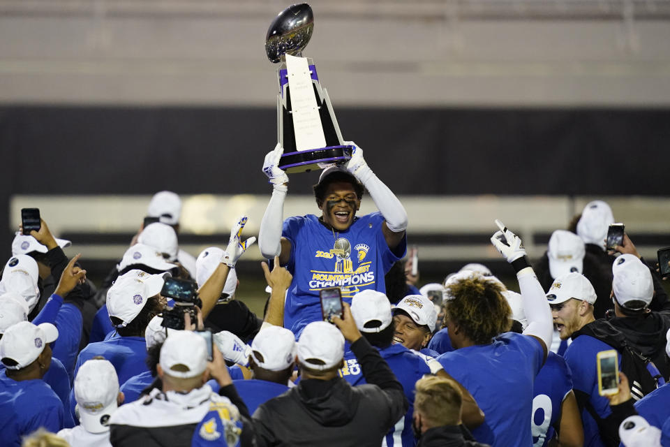 San Jose State cornerback Nehemiah Shelton holds the trophy while celebrating with teammates after defeating Boise State in an NCAA college football game for the Mountain West championship, Saturday, Dec. 19, 2020, in Las Vegas. (AP Photo/John Locher)