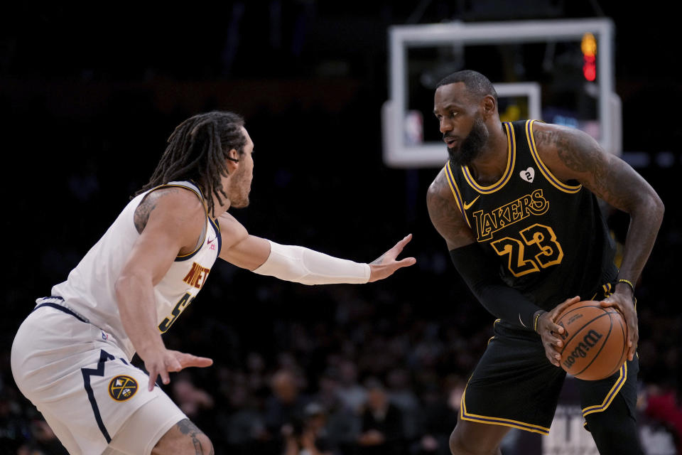 Los Angeles Lakers forward LeBron James (23) is defended by Denver Nuggets forward Aaron Gordon (50) during the first half of an NBA basketball game in Los Angeles, Thursday, Feb. 8, 2024. (AP Photo/Eric Thayer)
