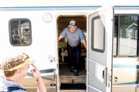 Volunteer firefighter John Hunter looks out from a donated motorhome he received from Woody Faircloth, left, on Sunday, Sept. 5, 2021, in Quincy, Calif. Hunter lost his home and hardware store to the Dixie Fire in August. (AP Photo/Noah Berger)