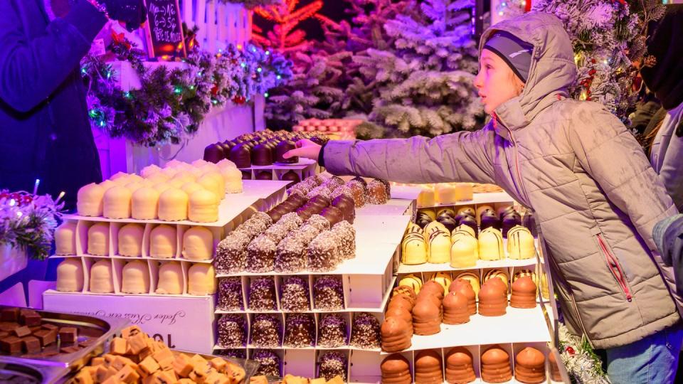 girl buying chocolate in brussels christmas market belgium