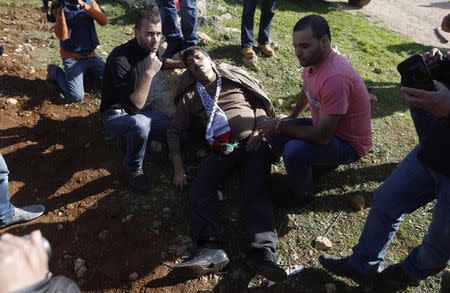 Palestinian minister Ziad Abu Ein (C) falls after being hit by Israeli soldiers during a protest near the West Bank city of Ramallah December 10, 2014. The Palestinian minister died on Wednesday shortly after an altercation with Israeli border police in the West Bank during which one of the policeman grabbed him by the neck. REUTERS/Mohamad Torokman