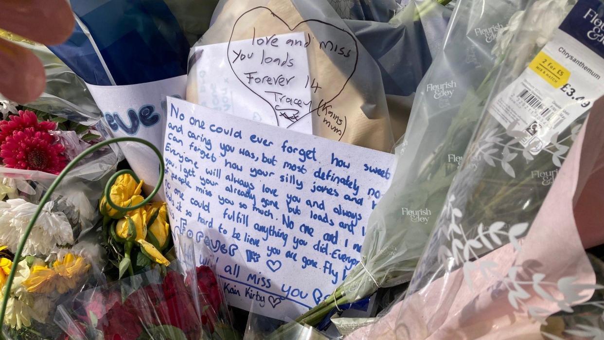 A hand-written message among the tributes at the scene of the fatal crash