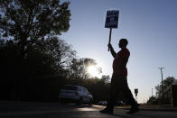 A member of the United Auto Workers walks the picket line at the General Motors Romulus Powertrain plant in Romulus, Mich., Wednesday, Oct. 9, 2019. Nearly four weeks into the United Auto Workers' strike against GM, employees are starting to feel the pinch of going without their regular paychecks. (AP Photo/Paul Sancya)