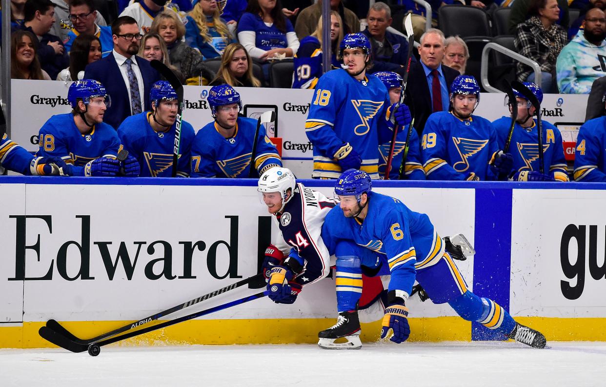 Nov 27, 2021; St. Louis, Missouri, USA;  St. Louis Blues defenseman Marco Scandella (6) and Columbus Blue Jackets center Gustav Nyquist (14) battle for the puck during the first period at Enterprise Center. Mandatory Credit: Jeff Curry-USA TODAY Sports