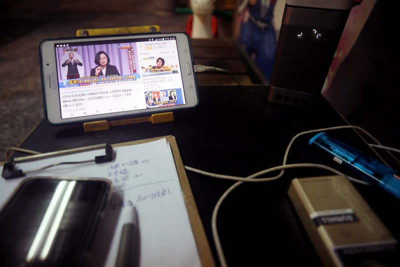 Taiwan President Tsai Ing-wen is seen on a phone screen during the third live policy address ahead of January's election, in Tainan