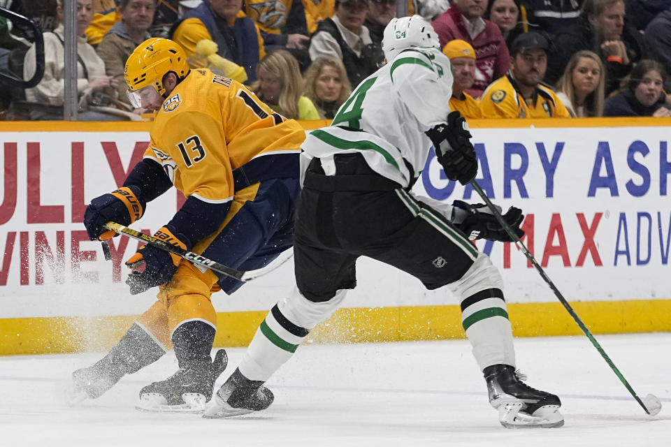 Nashville Predators center Yakov Trenin (13) steals the puck from Dallas Stars center Roope Hintz (24) during the second period of an NHL hockey game Saturday, Dec. 23, 2023, in Nashville, Tenn. (AP Photo/George Walker IV)