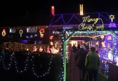 Visitors and locals view Christmas displays on dozens of properties that have been decorated in thousands of lights in a tradition that has grown over recent years in the small village of Westfield in Sussex, south east England, December 15, 2016. Picture taken on December 15. REUTERS/Toby Melville