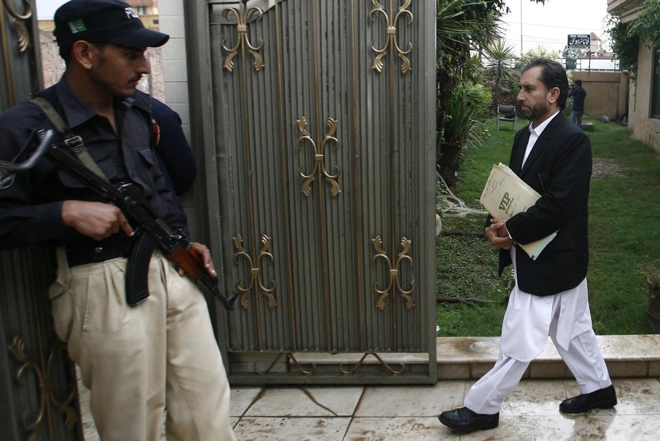 Samiullah Afridi (R), lawyer for doctor Shakil Afridi who ran a fake vaccination campaign to try to help U.S. officials find al-Qaeda chief Osama bin laden, leaves the court building in Peshawar October 30, 2013. Lawyer Afridi has fled Pakistan after receiving threats from militants, relatives said on December 11, 2013. He went abroad after militants threatened to blow up his car and kill his family, a relative said. Picture taken on October 30, 2013. REUTERS/Khuram Parvez (PAKISTAN - Tags: POLITICS CIVIL UNREST CRIME LAW)