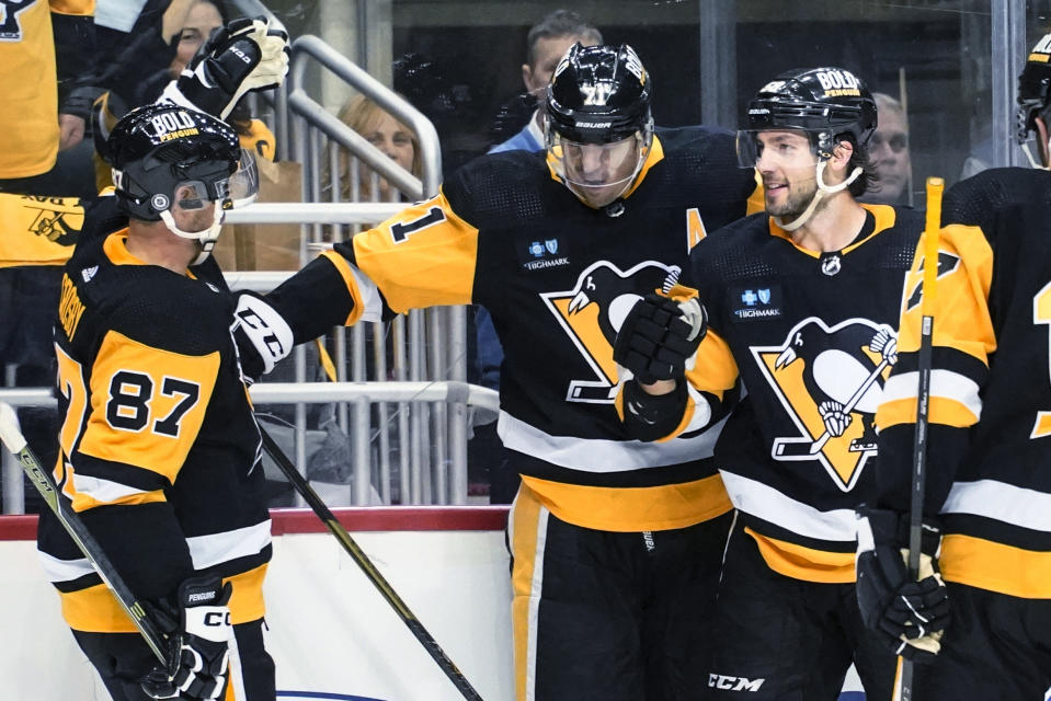 Pittsburgh Penguins' Evgeni Malkin (71) celebrates with Kris Letang (58) and Sidney Crosby (87) after scoring against the Arizona Coyotes during the second period of an NHL hockey game Thursday, Oct. 13, 2022, in Pittsburgh. (AP Photo/Keith Srakocic)