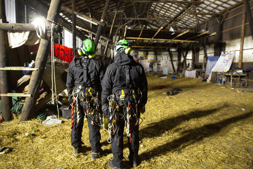 Height climbers of the police stand in a cleared warehouse, in Luetzerath, Germany, Wednesday, Jan. 11, 2023. Police in riot gear began evicting climate activists Wednesday from the condemned village in western Germany that is due to be demolished for the expansion of a coal mine. The government and utility company RWE argue the coal is needed to ensure Germany’s energy security. (Thomas Banneyer/dpa via AP)