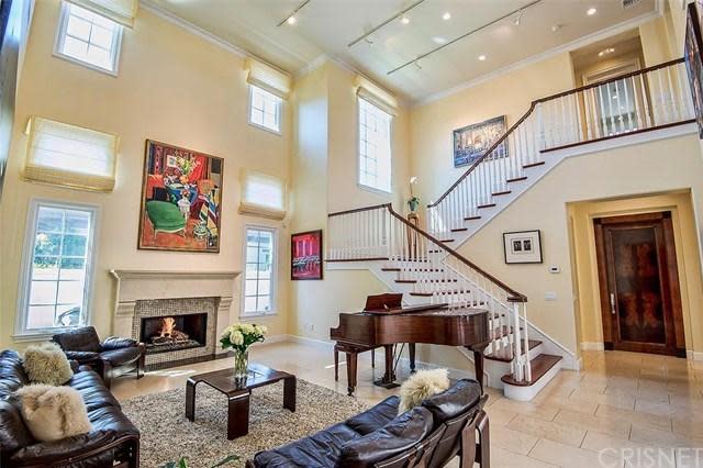 <p>The home features a stunning two-storey living room with a fireplace. (Trulia) </p>