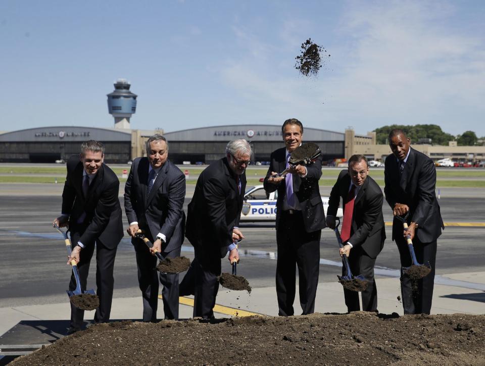 FILE- In this June 14, 2016 file photo, New York Gov. Andrew Cuomo, third from right, throws dirt in the air during a ceremonial ground breaking on the tarmac at LaGuardia Airport in New York. An ambitious Democratic governor with possible White House aspirations has a formula for staying blue in the time of Trump: Take your progressive message directly to angst-ridden middle-class voters. But some wonder just how sincere Cuomo really is, questioning whether his middle-class outreach formula that he defiantly posed as an alternative to Donald Trump is nothing more than the groundwork for a presidential run. And they question where this formula — combining progressive social programs and big spending on airports, train stations and water infrastructure — was during Cuomo's previous six years as governor. (AP Photo/Seth Wenig, File)