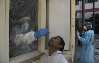 A health worker conducts COVID-19 test at a government hospital in New Delhi, India, Monday, Sept. 28, 2020. India’s confirmed coronavirus tally has reached 6 million cases, keeping the country second to the United States in number of reported cases since the pandemic began. (AP Photo/Manish Swarup)