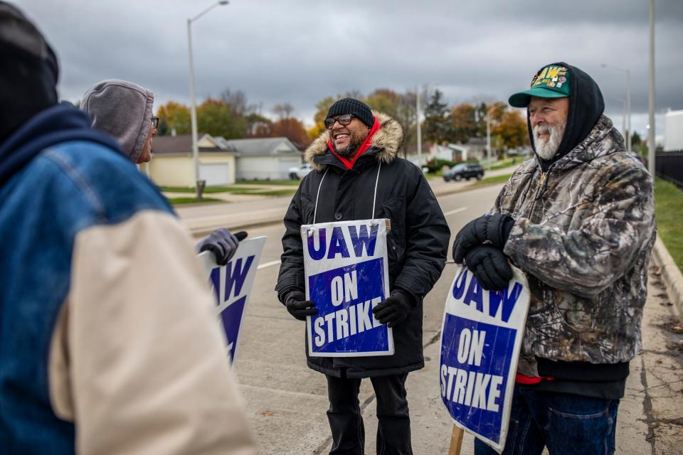 Jason Coburn, 46, of Auburn Hills, center, shares a light moment of laughter on the picket line with Gary Phillips 63, of Harrison Twp, left, and strike captain Vern Armstead, 64, of Davisburg, Mich., at the GM Customer Care and Aftersales plant in Pontiac, Mich., on Monday, Oct. 30, 2023.