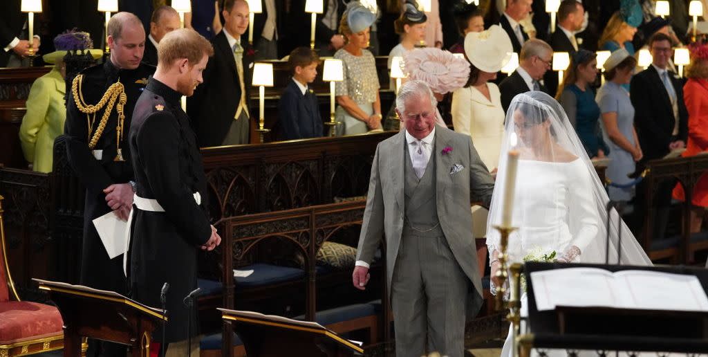topshot   britains prince harry, duke of sussex 2nd l, looks at his bride, meghan markle, as she arrives accompanied by the britains prince charles, prince of wales in st georges chapel during the wedding ceremony of britains prince harry, duke of sussex and us actress meghan markle in st georges chapel, windsor castle, in windsor, on may 19, 2018 photo by jonathan brady  pool  afp photo by jonathan bradypoolafp via getty images