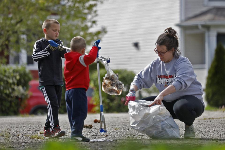 Jenny Garin a elementary school teacher takes a break from being inside their south side Columbus home to pick up trash with her sons Benny 3 and Caden 7. Caden's teacher had suggested the activity today and they have done it before but being Earth Day they were walking their neighborhood to clean up April 22, 2020.[Eric Albrecht/Dispatch]