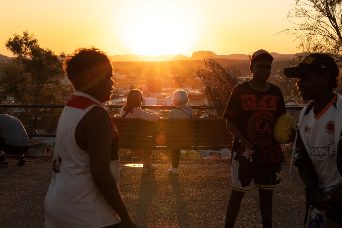 Boys play as people watch the sunset over Alice Springs (Reuters)