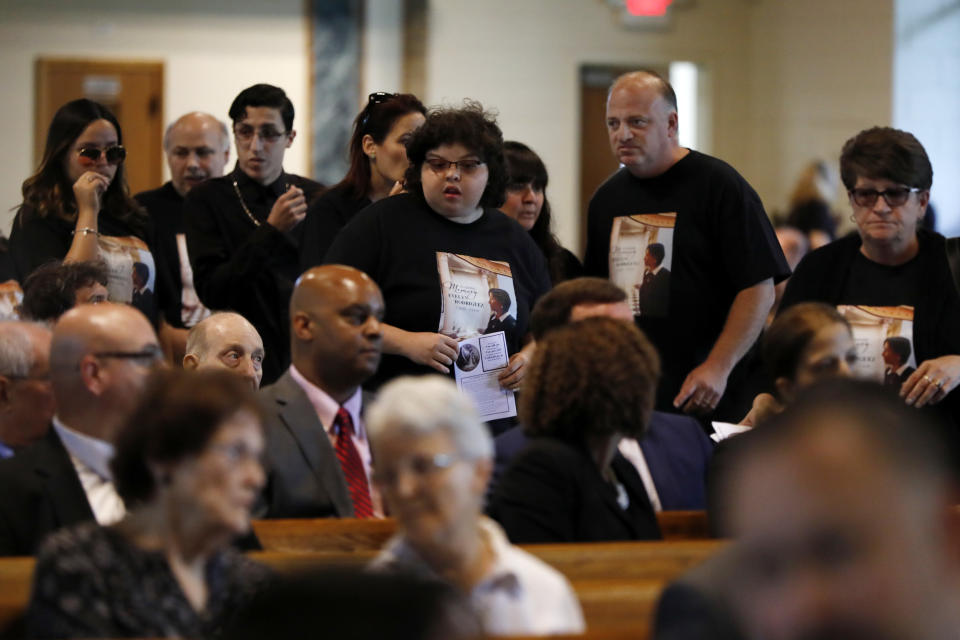 Mourners arrive for the funeral for Evelyn Rodriguez, at Saint Anne's Roman Catholic Church, in Brentwood, N.Y., Friday, Sept. 21, 2018. Rodriguez, 50, is a mother recognized by President Donald Trump for turning grief over her daughter's suspected gang killing into a crusade against MS-13. She was struck and killed by an SUV on Sept. 14 after a heated confrontation with the driver over the placement of a memorial to her slain daughter, Kayla Cuevas. (AP Photo/Richard Drew)