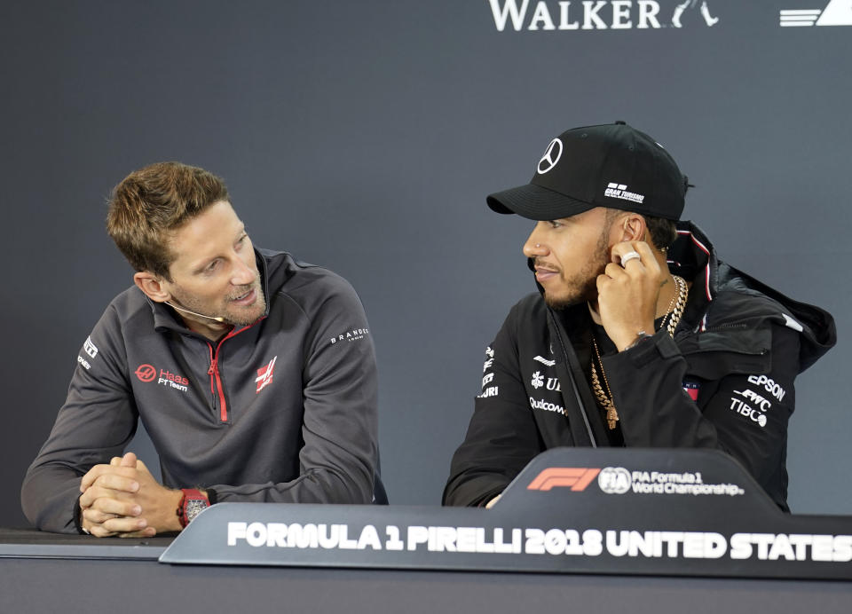 Haas driver Romain Grosjean, left, of France, talks with Mercedes driver Lewis Hamilton, of Britain, during a news conference for the Formula One U.S. Grand Prix auto race at the Circuit of the Americas, Thursday, Oct. 18, 2018, in Austin, Texas. (AP Photo/Darren Abate)