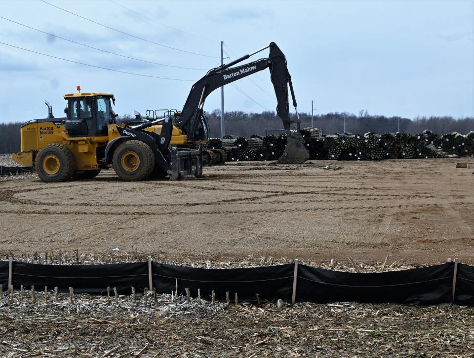 Thousand of fence poles are stacked in the layout yard off Burlington Road that will surround the 1000-plus-acre DTE solar farm .