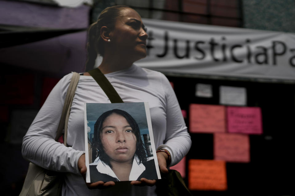 Alejandra Jiménez sostiene una imagen de Amarirany Roblero, quien desapareció hace 12 años, durante una protesta frente a un departamento alquilado por un presunto asesino en serie, en el barrio Iztacalco de la Ciudad de México, el viernes 26 de abril de 2024. (Foto AP/ Marco Ugarte)