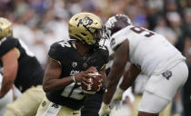 Colorado quarterback Brendon Lewis evades Texas A&M defenders in the second half of an NCAA college football game Saturday, Sept. 11, 2021, in Denver. Texas A&M won 10-7. (AP Photo/David Zalubowski)