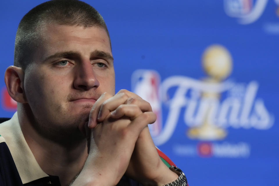 Denver Nuggets center Nikola Jokic (15) listens to a question during a post game news conference after Game 3 of the NBA Finals basketball game against the Miami Heat, Thursday, June 8, 2023, in Miami. (AP Photo/Rebecca Blackwell)