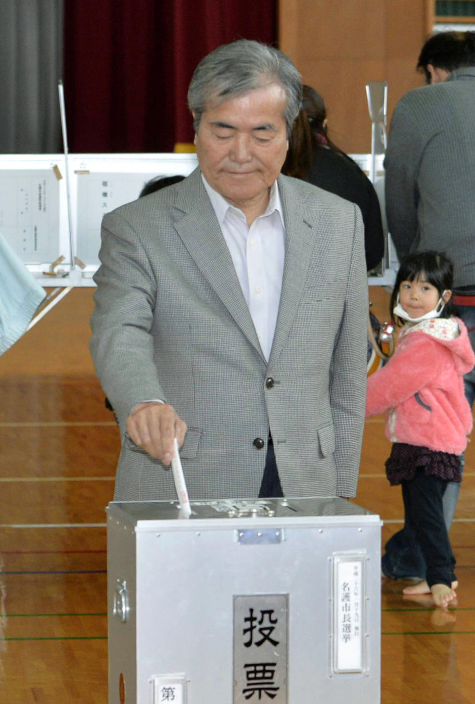 Nago city mayoral candidate Bunshin Suematsu casts his ballot in the mayoral election in Nago, on the southern Japanese island of Okinawa, Sunday, Jan. 19, 2014. The small-town mayoral election is being closely watched from Washington to Tokyo as a referendum on long-delayed plans to move a U.S. air base to the community of 62,000 people. Nago Mayor Susumu Inamine, who opposes the move, faces pro-relocation candidate Suematsu in the election. (AP Photo/Kyodo News) JAPAN OUT, CREDIT MANDATORY