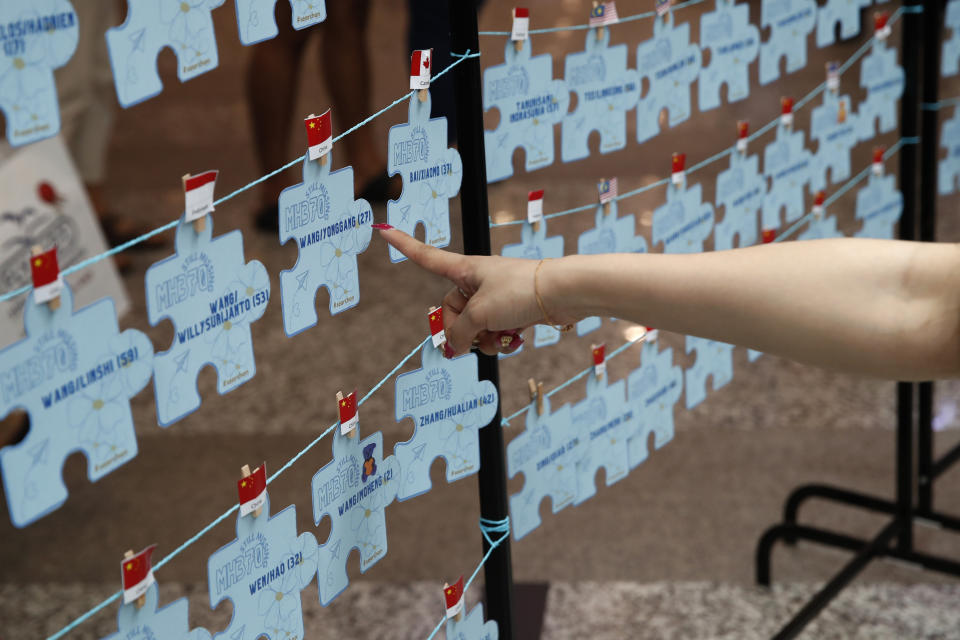 A family member of passengers on board of the missing Malaysia Airlines Flight 370 points at the names tag of the missing passengers during the tenth annual remembrance event at a shopping mall, in Subang Jaya, on the outskirts of Kuala Lumpur, Malaysia, Sunday, March 3, 2024. Ten years ago, a Malaysia Airlines Flight 370, had disappeared March 8, 2014 while en route from Kuala Lumpur to Beijing with 239 people on board. (AP Photo/FL Wong)