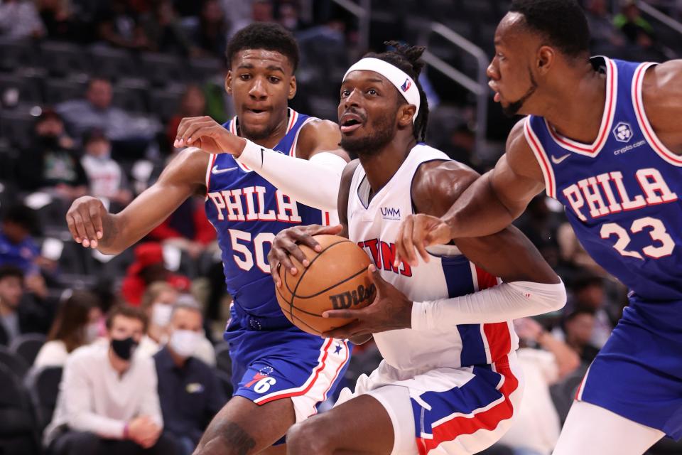 Jerami Grant (9) of the Detroit Pistons tries to split the defense of Aaron Henry (50) and Charles Bassey (23) of the Philadelphia 76ers during a preseason game at Little Caesars Arena on Oct. 15, 2021 in Detroit.