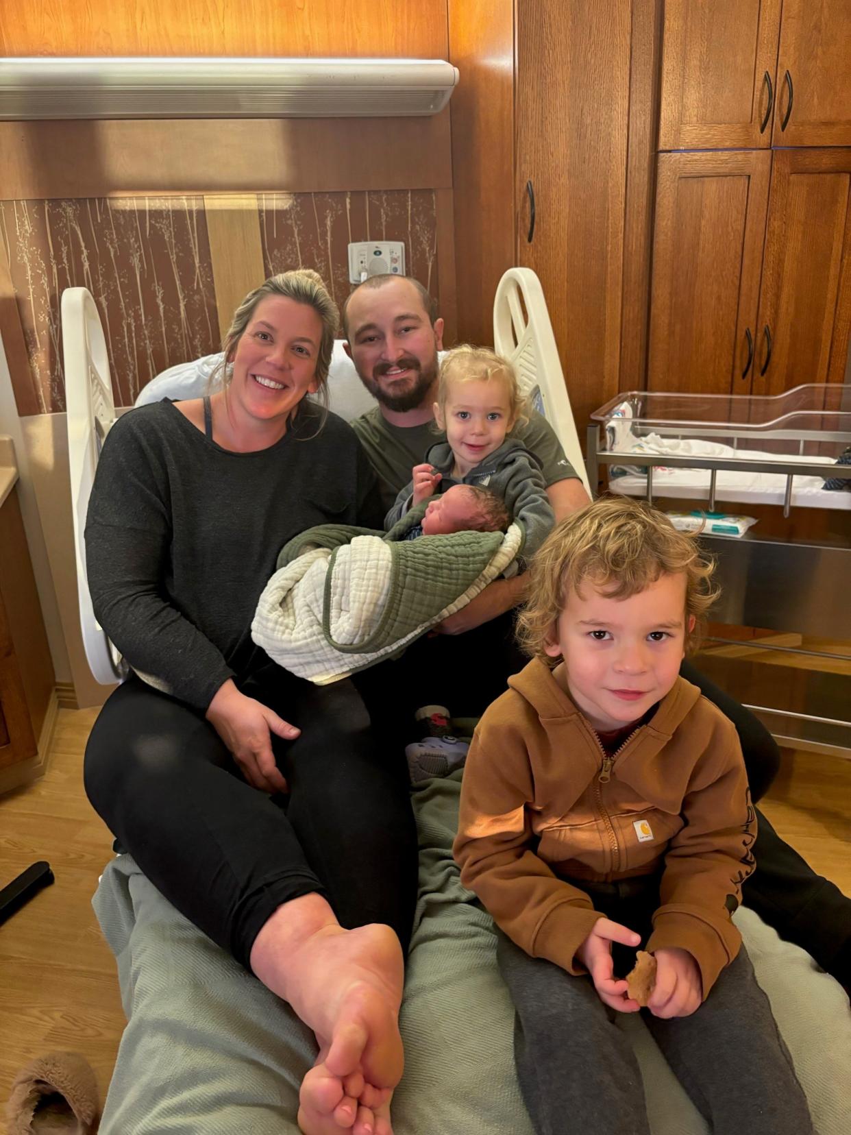 The Hertel family of Belt, Montana welcome their new addition baby Beau, the first to be born at Benefis Health System in 2024. From left to right are Ellyn Hertel, father Kelly Hertel, baby Beau and his sister Josie. Sitting at the foot of the bed is big brother Charlie Hertel.