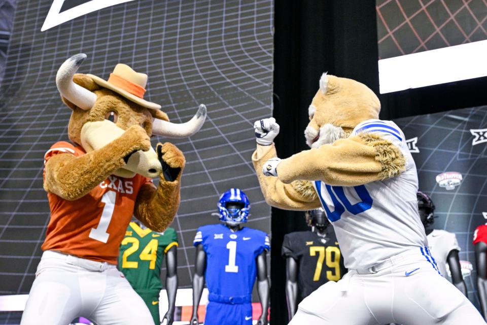 The mascots for the Texas Longhorns and BYU Cougars pretend to fight on the stage before the start of the Big 12 football media days on July 13 at AT&T Stadium in Arlington, Texas.