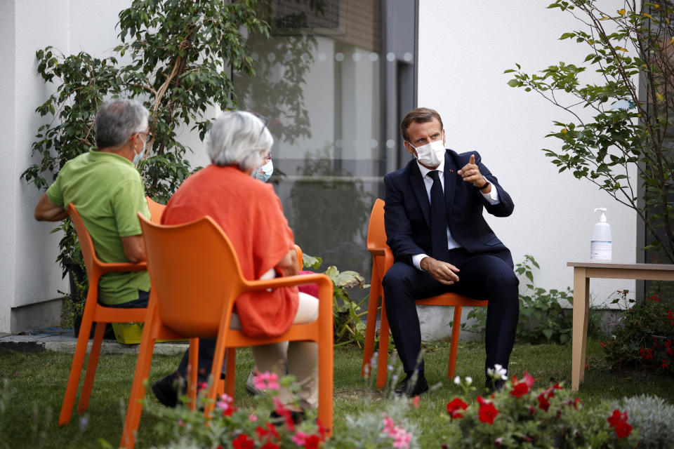 French President Emmanuel Macron, right, talks to residents at the 'La Bonne Eure' nursing home in Bracieux, central France, Tuesday, Sept. 22, 2020. For the first time in months, virus infections and deaths in French nursing homes are on the rise again. (Yoan Valat/Pool Photo via AP)