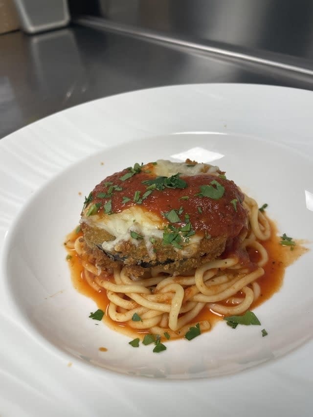 pasta with marinara sauce and eggplant parmesan on top