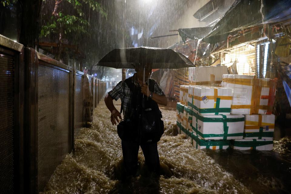 A man walks past a flooded area during heavy rain in Hong Kong.