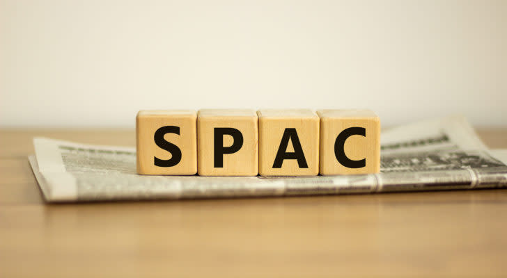 A photo of wooden blocks that say SPAC on a folded newspaper. PSTH is a SPAC