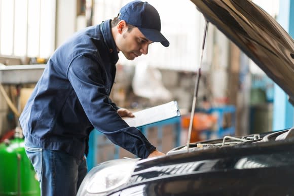 Mechanic looking at car engine