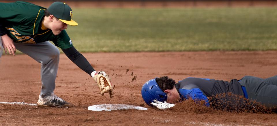 Gibraltar Carlson's Robert MacAleese steals third base with Bryce Elliott of Flat Rock covering the bag in the season opener earlier this month.