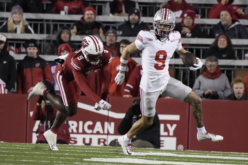 Ohio State's Jayden Ballard (9) runs past Wisconsin's Quincy Burroughs during the first half of an NCAA college football game Saturday, Oct. 28, 2023, in Madison, Wis. (AP Photo/Morry Gash)
