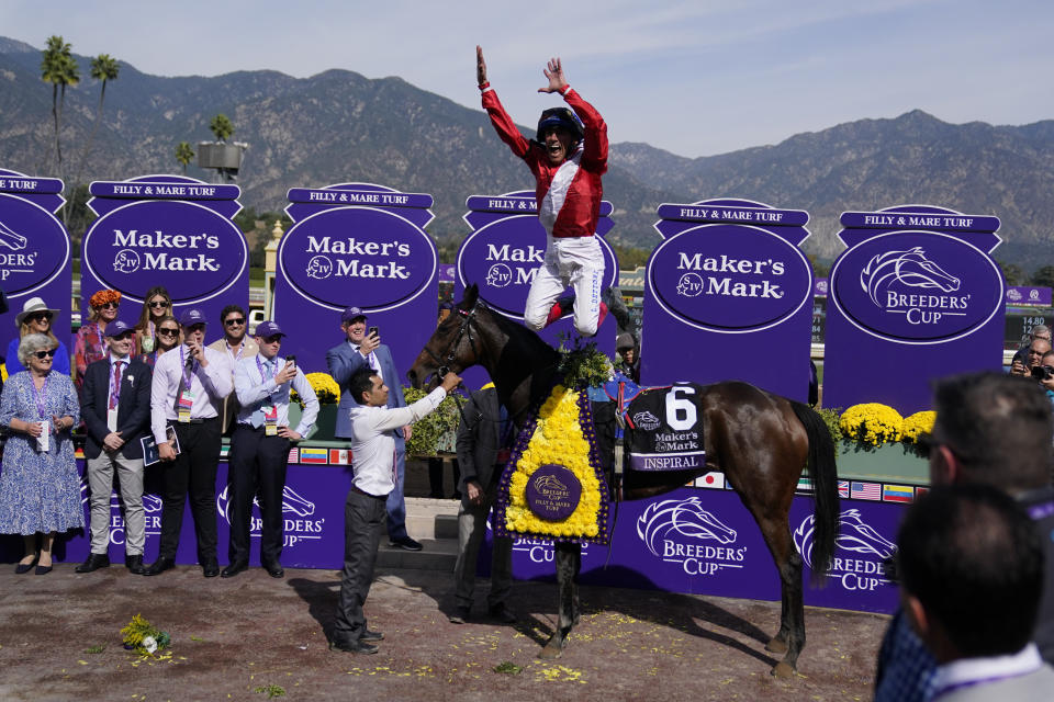 Jockey Frankie Dettori leaps off of Inspiral after winning the Breeders' Cup Filly and Mare Turf horse race Saturday, Nov. 4, 2023, at Santa Anita Park in Arcadia, Calif. (AP Photo/Ashley Landis)