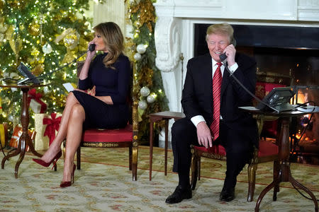 U.S. President Donald Trump and first lady Melania Trump participate in NORAD Santa tracker phone calls from the White House in Washington, U.S. December 24, 2018. REUTERS/Jonathan Ernst